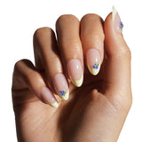 Hand with nails painted in a light color with decorative elements on a white background
