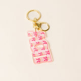 Pink floral sorority letter acrylic keychain with gold keyring on neutral background