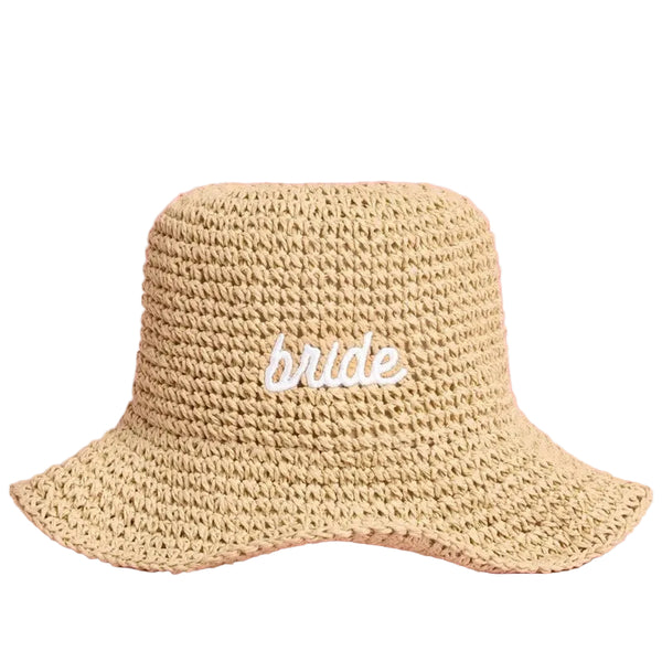 Beige straw bucket hat with 'bride' embroidered text on pink background