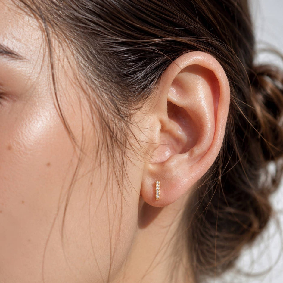 Pave Stick Post Earring worn on model's ear, gold diamond studs