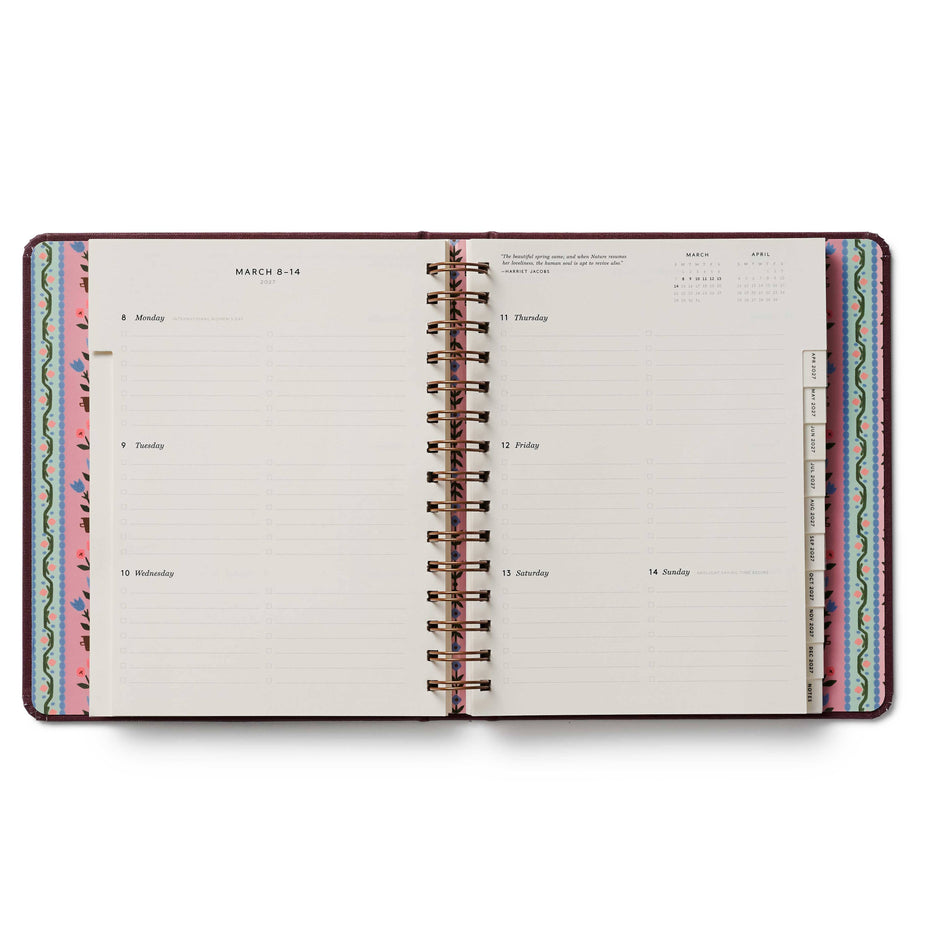 Open planner with colorful spiral binding on a white background
