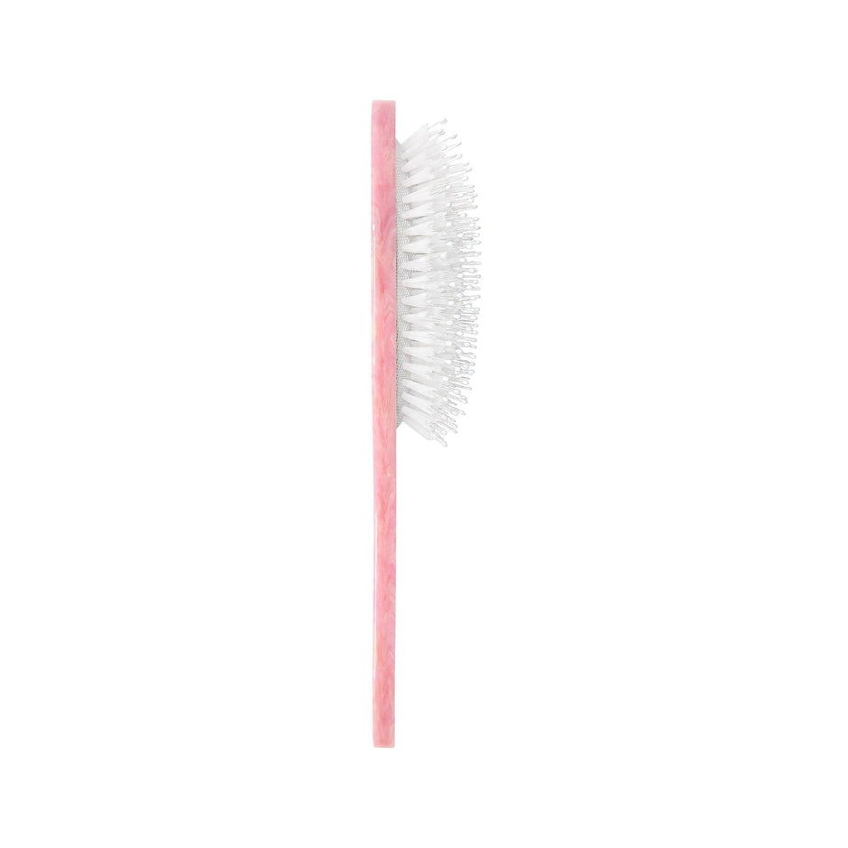 Pink eco-friendly Shih Tzu pup brush with white bristles on neutral background