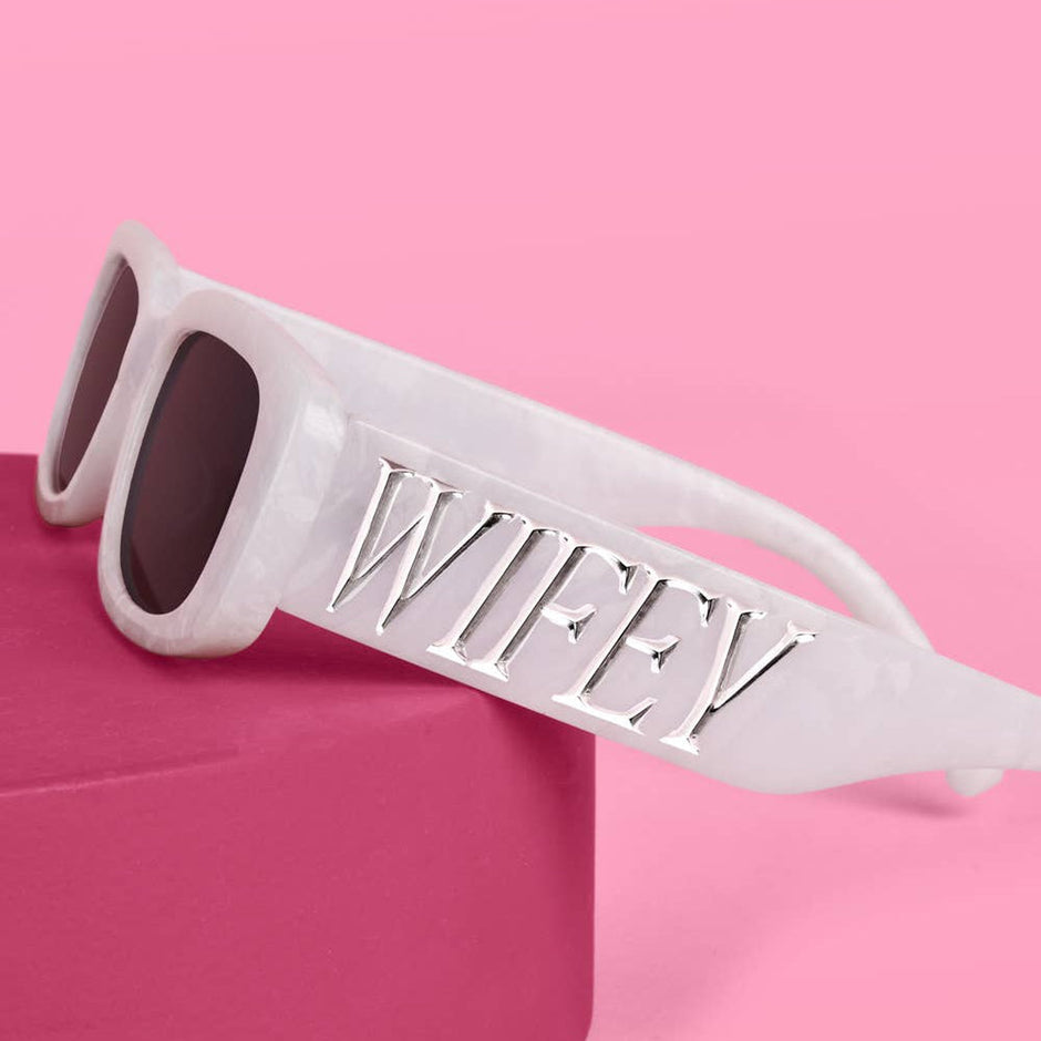 White Wifey sunglasses with silver lettering on pink background