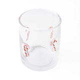Clear drinking glass with red and white candy cane designs printed on sides, shown against white background