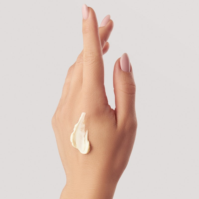 Hand balm swatch on woman's hand showing creamy texture and application