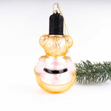 Pink and gold teddy bear glass Christmas ornament with black glitter hat and evergreen branch