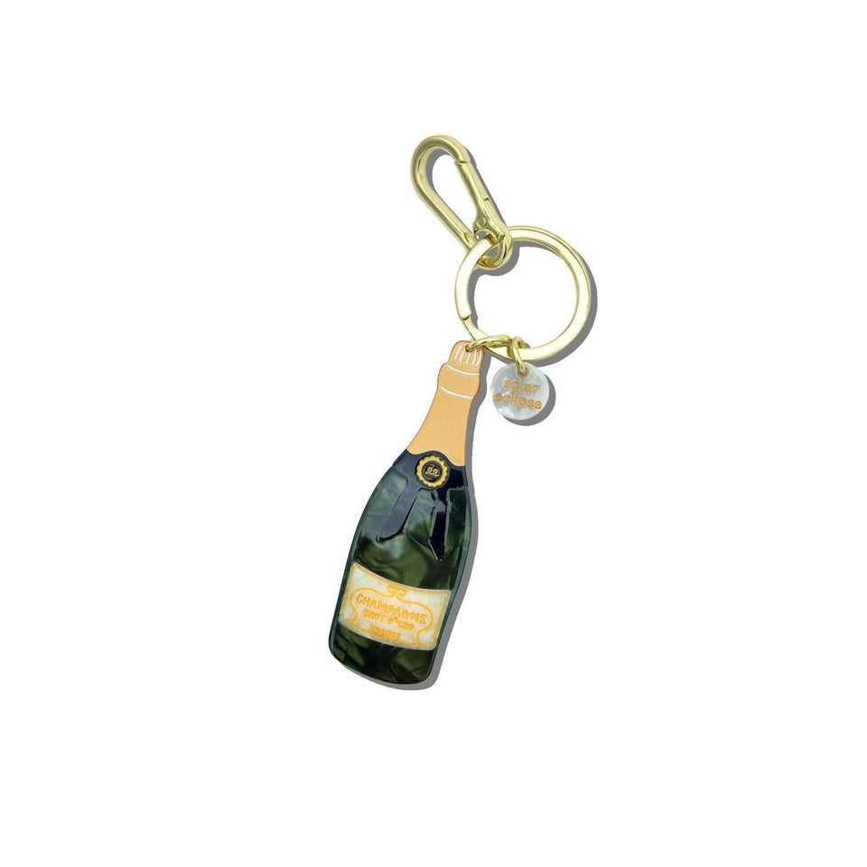 Hand-painted champagne bottle bag charm keychain with gold accents and charms on white background