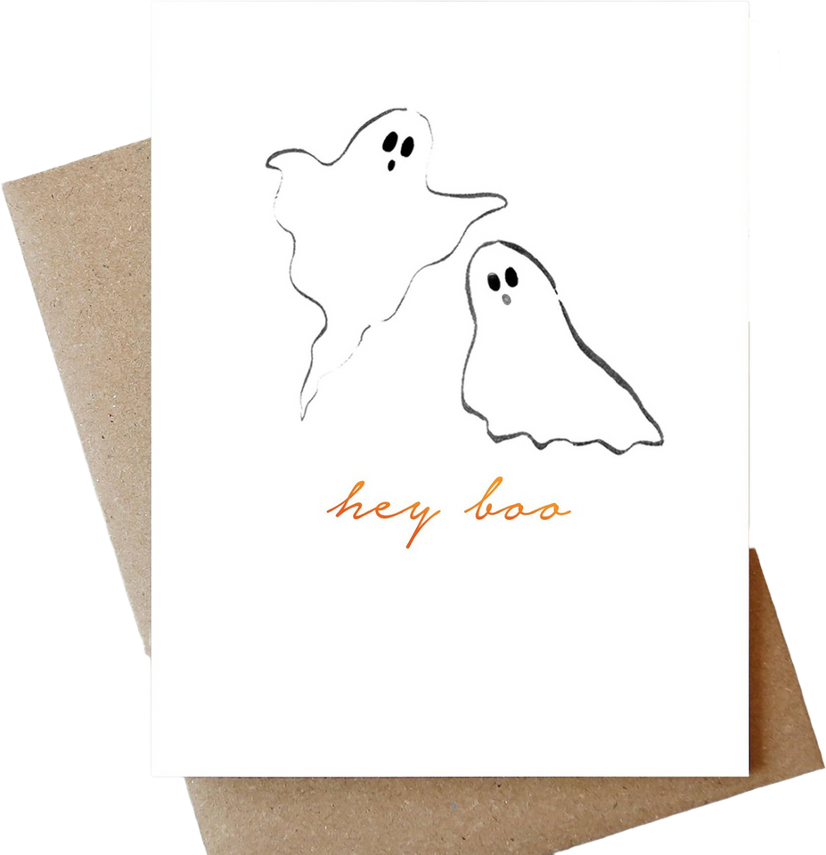 A white greeting card with minimalist black ghost illustrations and the words 'hey boo' in orange script, shown with a brown kraft envelope on a white background.