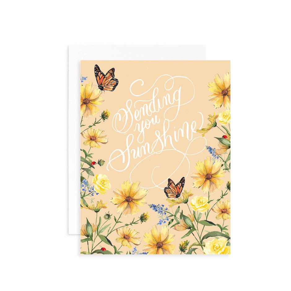 Greeting card with yellow flowers, butterflies, and 'Sending you sunshine' text on a beige background