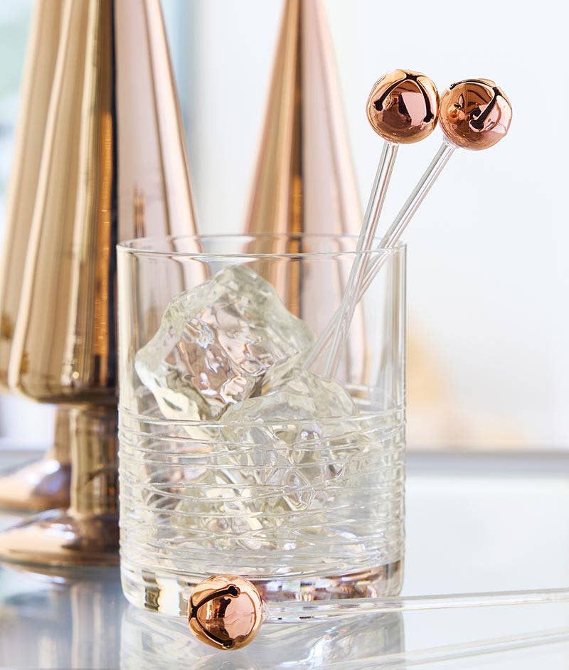 Rose gold jingle bell stir sticks in a cocktail