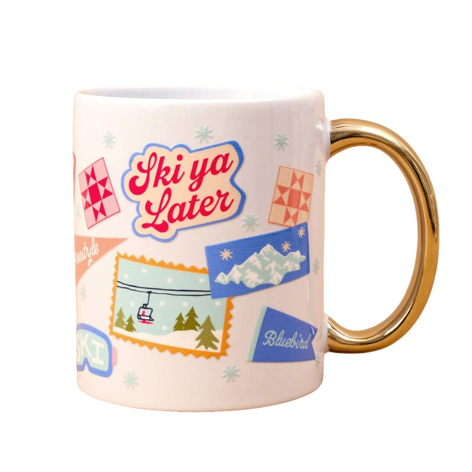 Ski Ya Later ceramic mug with gold handle featuring retro ski resort graphics and snowflake designs