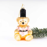 Gold and pink glitter teddy bear Christmas ornament with black top hat and evergreen branch