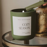 Cozy Season soy candle in matte green jar with wooden wick, styled home decor display