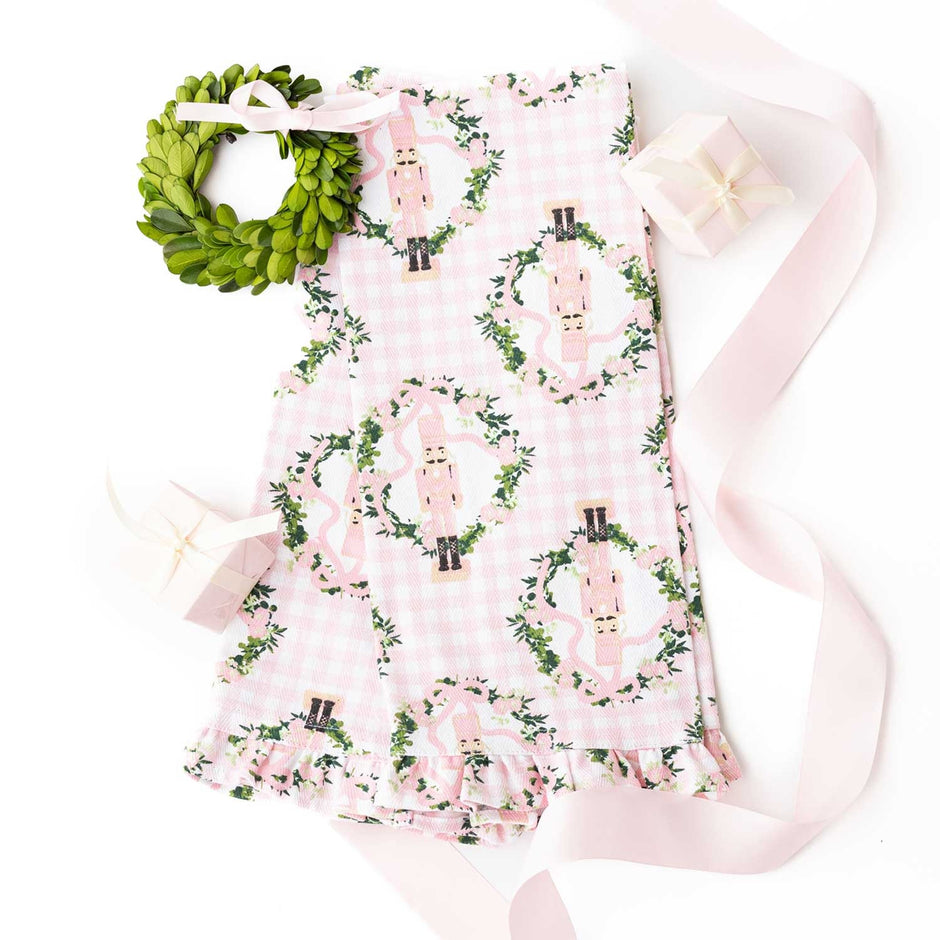 Pink gingham kitchen towel set with nutcracker and ivy pattern, styled with wreath and ribbon