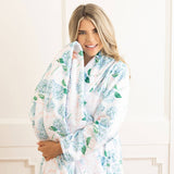 Woman wearing 8 Oak Lane Hydrangea Ribbons Luxe Robe with blue floral pattern in white interior setting