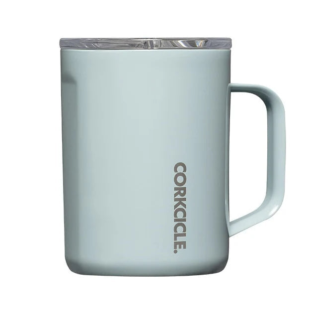 A light blue insulated mug with a clear lid and a vertical CORKICLE logo printed on the front, set against a plain white background.