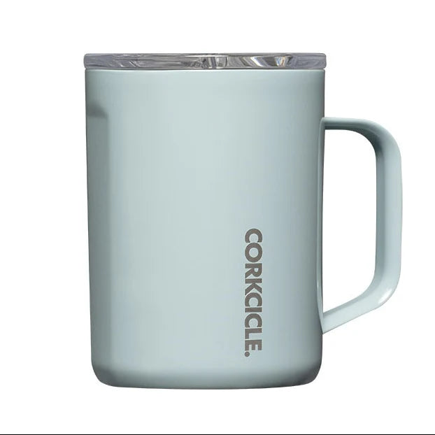 A light blue insulated mug with a clear lid and a vertical CORKICLE logo printed on the front, set against a plain white background.