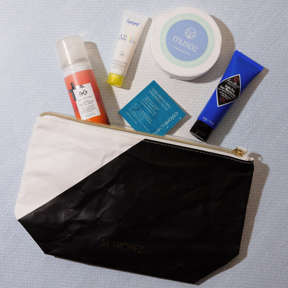 Cosmetic bag with skincare products on a gray background