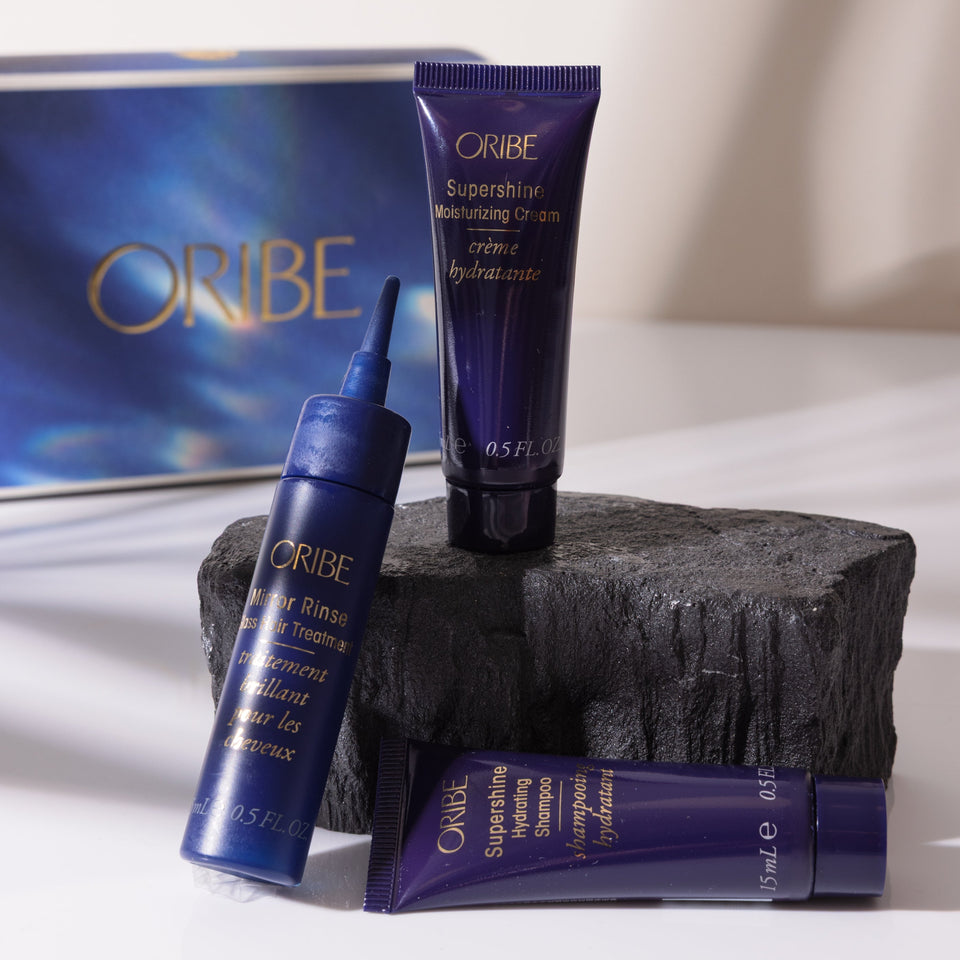 Oribe hair care products on a white surface with a blue box in the background