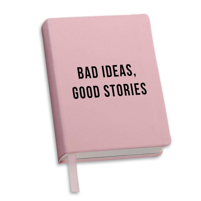 Pink hardcover journal with 'Bad Ideas, Good Stories' text on cover and bookmark ribbon