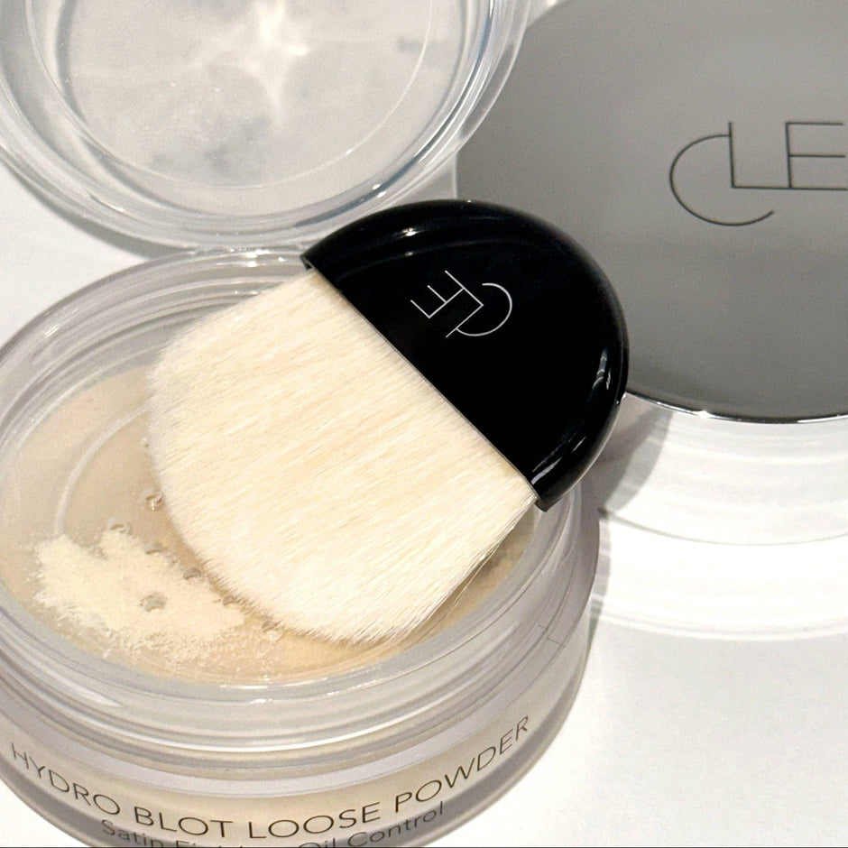 CLE Cosmetics Hydro Blot Loose Powder with brush applicator and open compact on white background