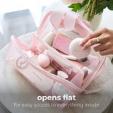Pink cosmetic bag opened flat displaying makeup brushes, powders, and beauty products inside