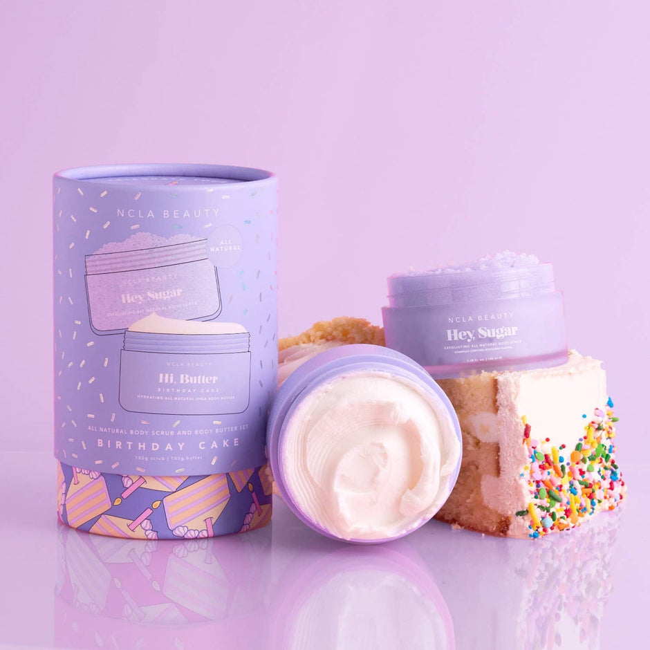 NCLA Beauty Birthday Cake Body Scrub and Body Butter Set with decorative packaging and cake props