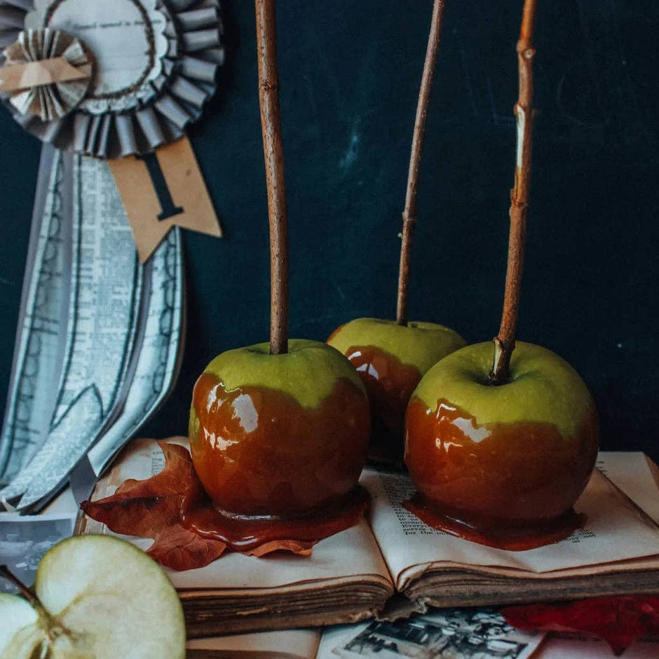 Poison Apple Mixer Cubes displayed in Halloween-themed styled setting with vintage book and decorative elements