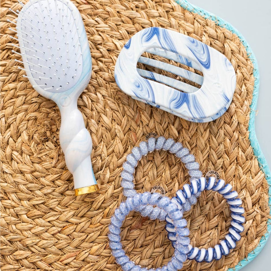 TELETIES Tide & True hair clips and brush displayed on woven natural texture background