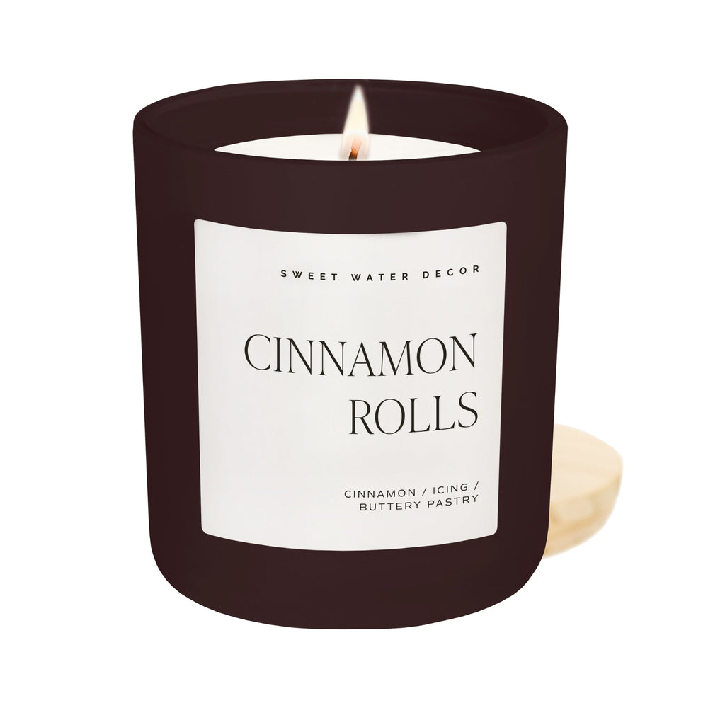 Sweet Water Decor Cinnamon Rolls 15 oz soy candle in matte dark brown jar with lit flame