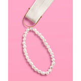 Pearl beaded bracelet with white ribbon charm on pink background