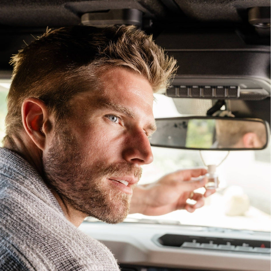 Man using Volcano Car Diffuser in vehicle interior, citrus pineapple scent