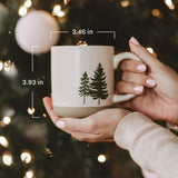 Stoneware coffee mug with evergreen tree design, 3.46 in width, 3.93 in height measurement overlay