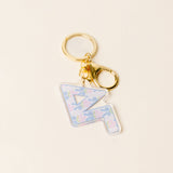 Sorority letter acrylic keychain with floral design and gold-tone hardware on neutral background