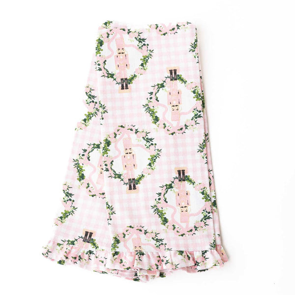 Pink gingham kitchen towel with nutcracker and ivy vine pattern, featuring ruffled edge