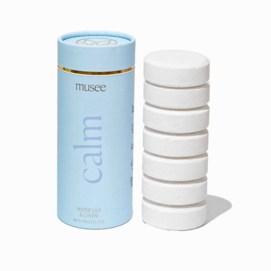 MUSEE Calm Bath Tabs in Water Lily & Linen scent with light blue cylindrical packaging and white tablet stack