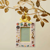 Baby's First Christmas picture frame ornament with yellow ribbon hung from dried botanical branches