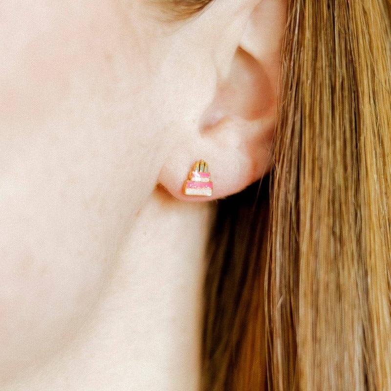 Birthday cake screwback stud earrings worn on model with long brown hair