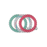 Six colorful spiral hair ties in mint, pink, white, and hot pink displayed on black background