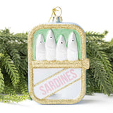 Gold glitter sardine tin ornament displayed among evergreen branches