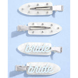 Four pearl white bride hair clips with crystals and metallic accents on blue background
