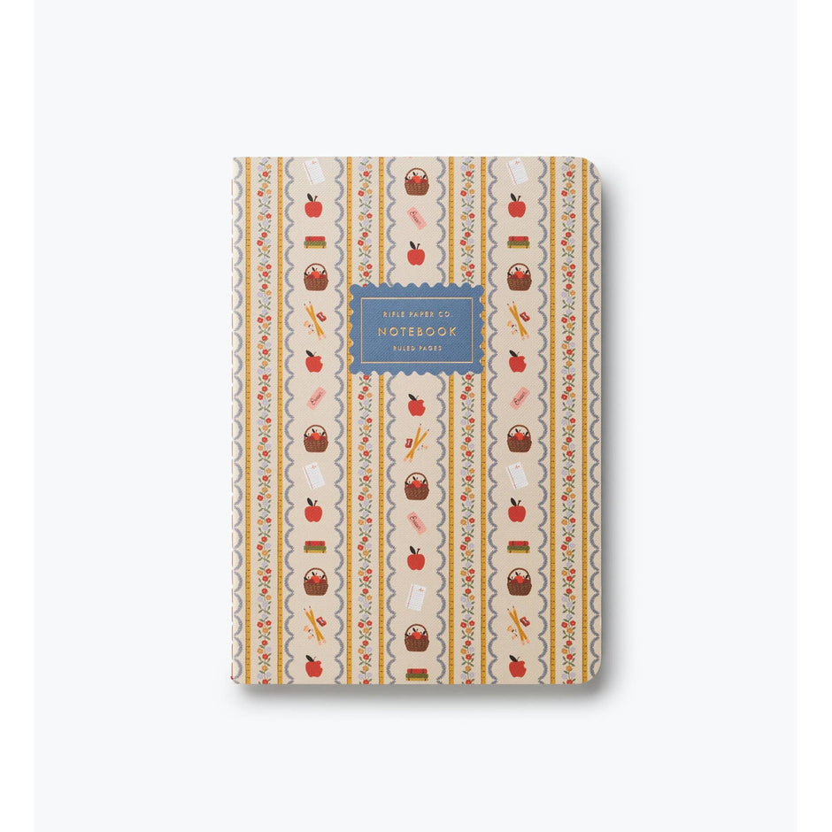Rifle Paper Co. Schoolhouse notebook with cream cover featuring red apples, baskets, and floral stripe pattern