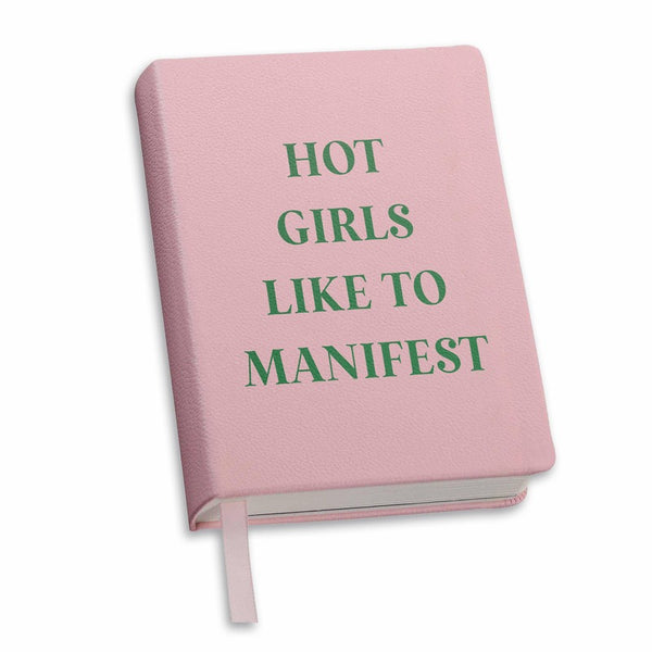 Pink hardcover journal with green text reading 'Hot Girls Like to Manifest' and ribbon bookmark