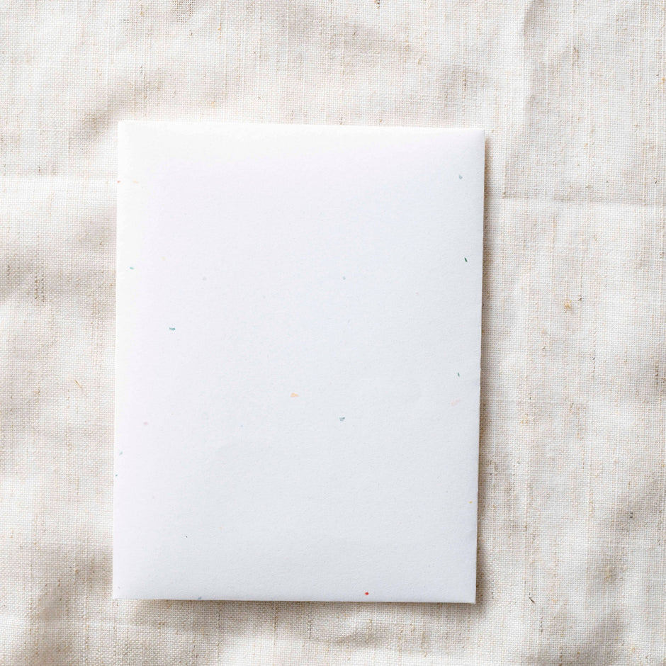 Blank white greeting card on beige linen background by Paper Baristas