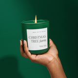 Sweet Water Decor Christmas Tree Farm soy candle held in hand against green background