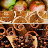 Fall candle scent ingredients: apples, oranges, cinnamon sticks, and cloves displayed with labels