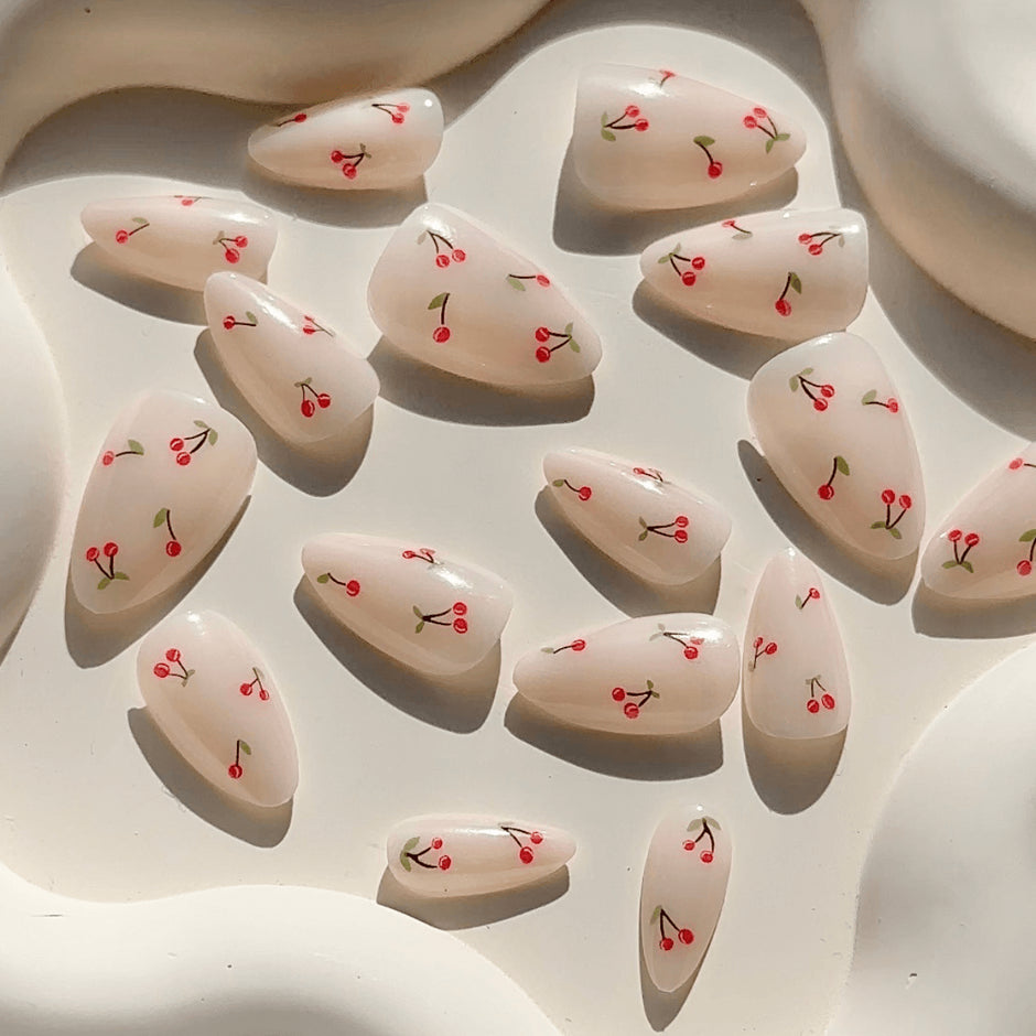 Nail art designs with cherries on a light background