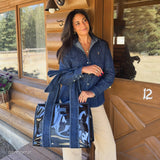 Woman holding denim bow jelly tote bag in cabin setting with forest views
