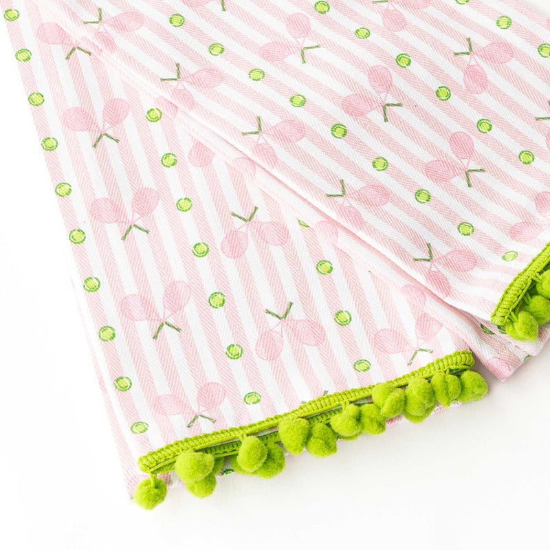 Pink tennis stripe kitchen towel with green pom-pom trim detail on white background
