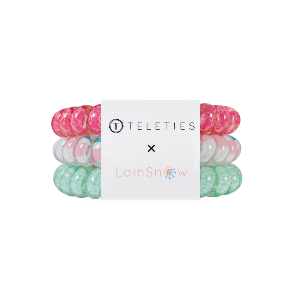 TELETIES x LainSnow large hair ties in pink, white, and green coiled stack on black background